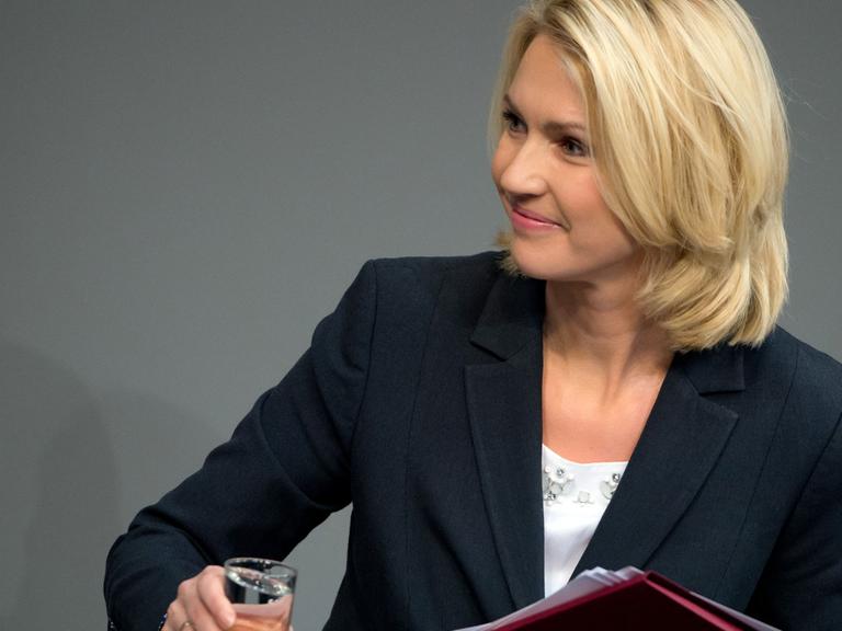 Die Bundesministerin für Familie, Frauen, Jugend und Senioren, Manuela Schwesig (SPD), hält am 06.03.2015 in Berlin während der Sitzung des Bundestages nach ihrer Rede lächelnd ein Glas in der Hand.