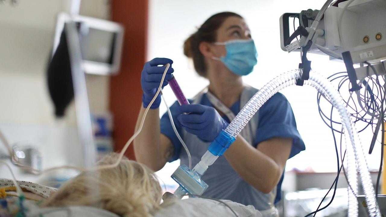 Im Intensiv- und Überwachungsbereich eines Krankenhauses wird eine Patientin von einer Krankenschwester medizinisch versorgt.