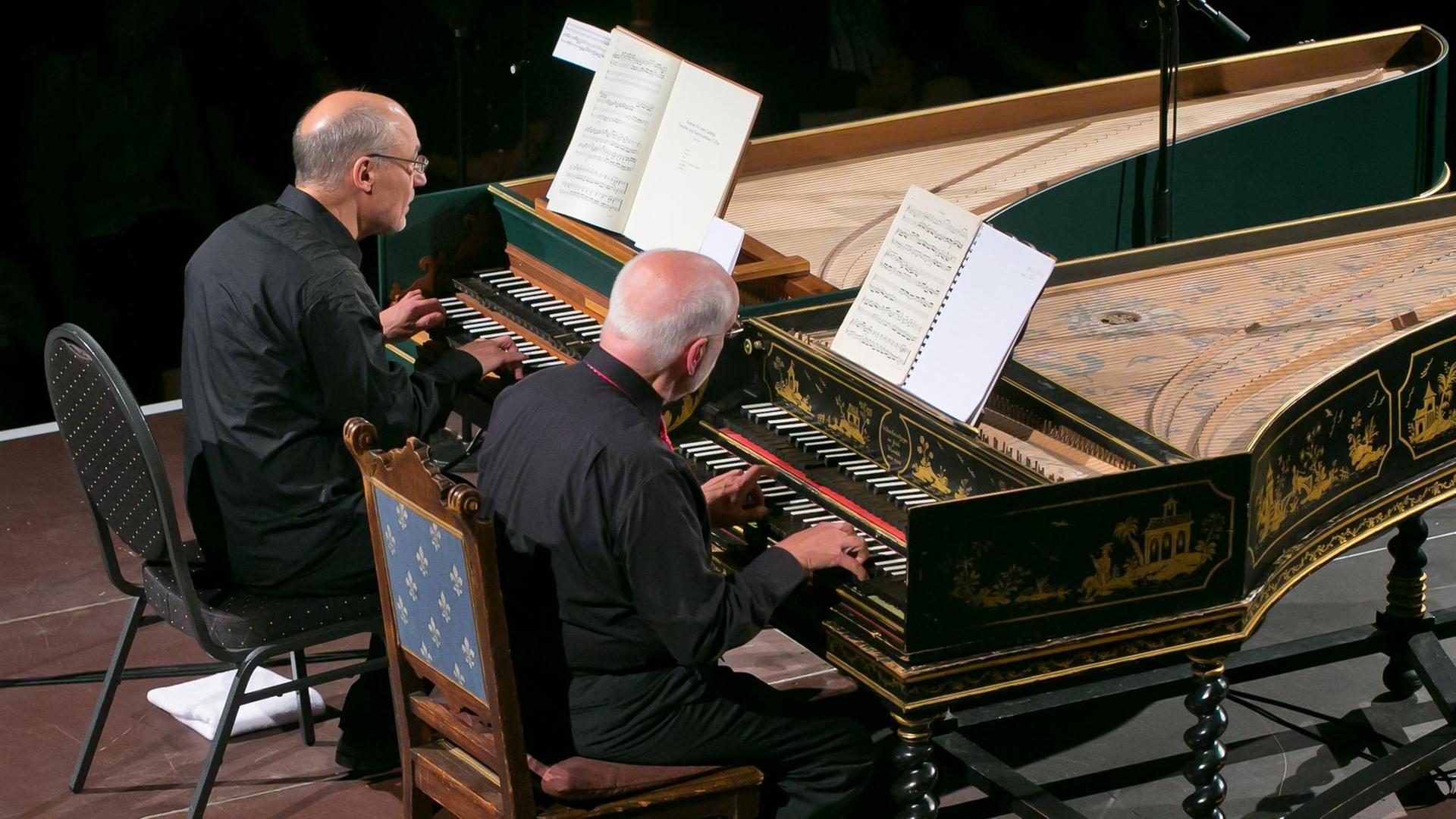 An zwei Cembali, die nebeneinander stehen, sitzen die beiden Musiker. An zwei Cembali, die nebeneinander stehen, sitzen die beiden Musiker.