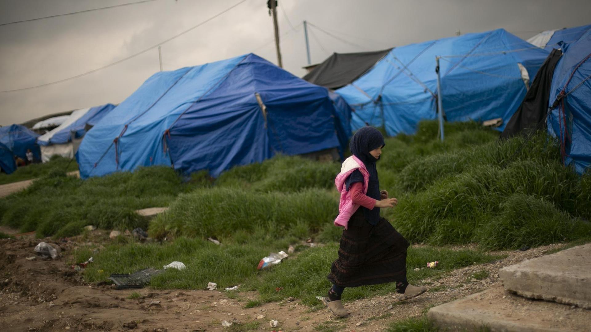 Auf diesem Foto vom 27. März 2019 geht ein Mädchen durch einen Zeltbereich im Lager Roj, wo Familien von Anhängern des Islamischen Staates festgehalten werden, in der Nähe von Derik, Syrien. Auf diesem Foto vom 27. März 2019 geht ein Mädchen durch einen Zeltbereich im Lager Roj, wo Familien von Anhängern des Islamischen Staates festgehalten werden, in der Nähe von Derik, Syrien.