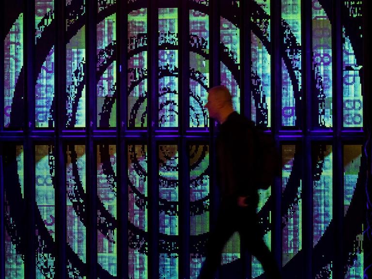 Ein Teilnehmer des 36C3 Chaos Communication Congress vor einer digitalen Installtionswand mit Kreis- und Ziffer-Elementen.