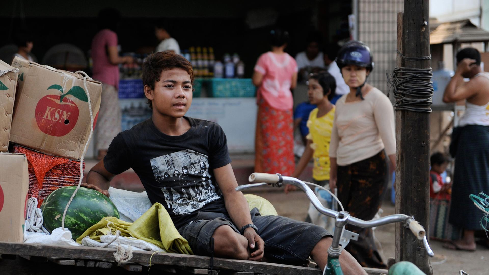Ein Junge verkauft Melonen auf einem Markt in Bagan, Myanmar. Ein Junge verkauft Melonen auf einem Markt in Bagan, Myanmar.