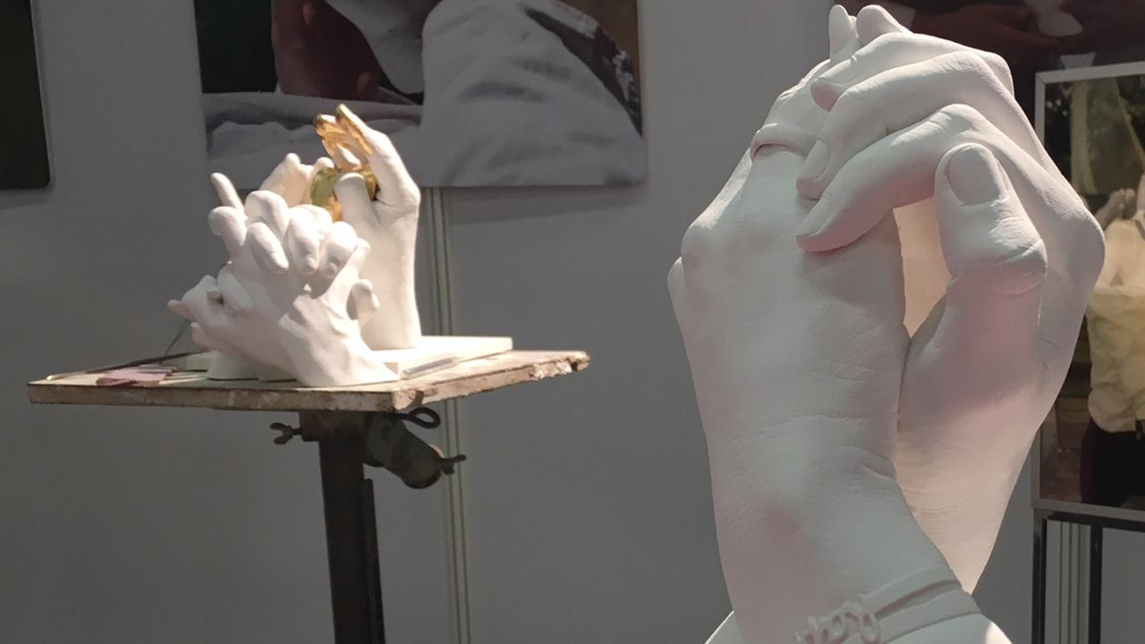 Hände aus Gips mit einem Ehering am Ringfinger Hände aus Gips mit einem Ehering am Ringfinger