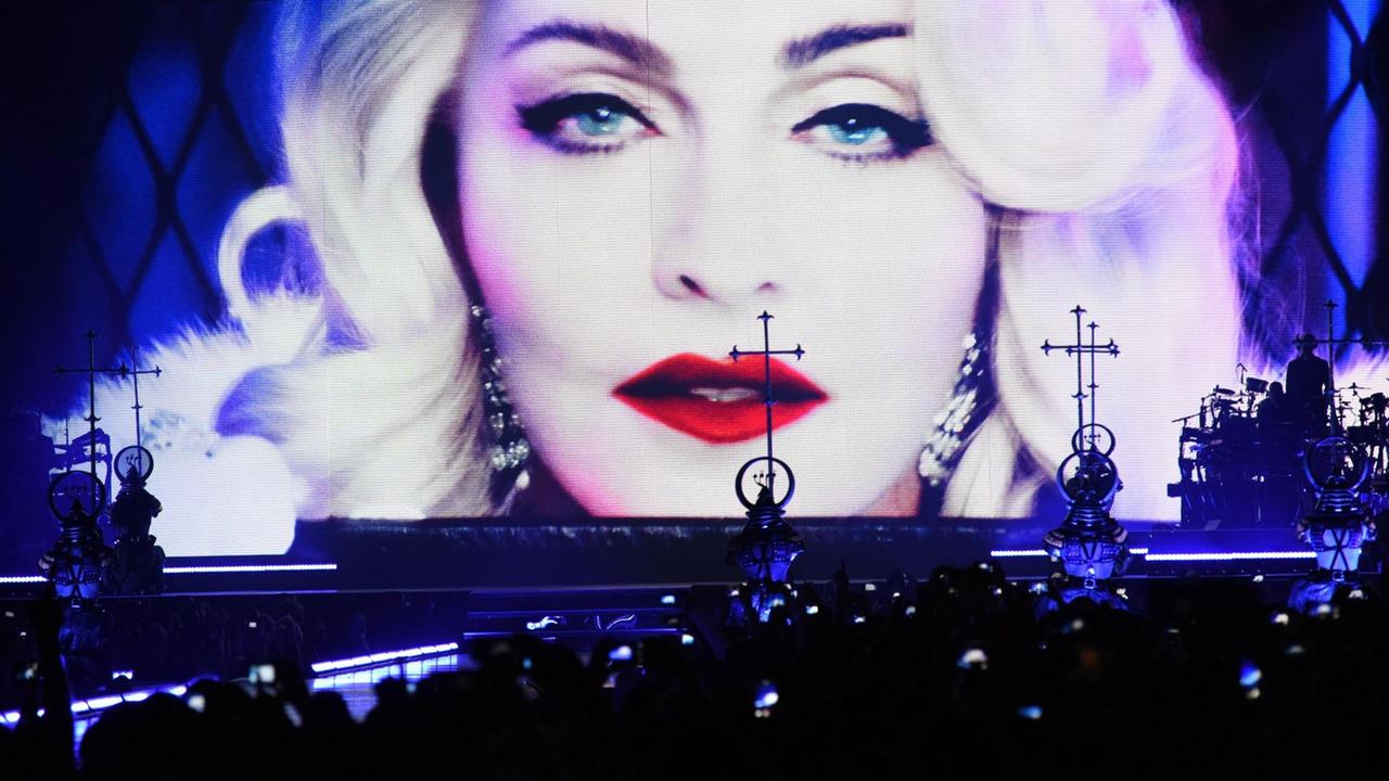 Das Gesicht Madonnas in Nahaufnahme auf einen großen Leinwand vor Konzertpublikum Das Gesicht Madonnas in Nahaufnahme auf einen großen Leinwand vor Konzertpublikum