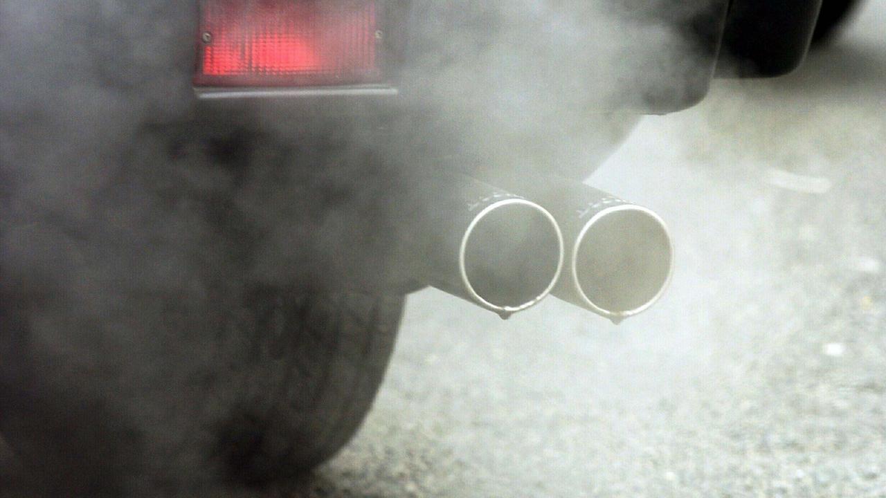Abgase entweichen den Auspuffrohren eines Autos Abgase entweichen den Auspuffrohren eines Autos
