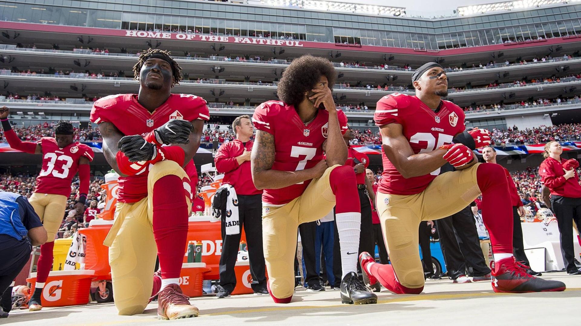 Colin Kaepernick (Mitte) kniet zusammen mit Eli Harold und Eric Reid vor einem Football-Spiel im Stadion am 2. Oktober 2016 in Santa Clara, Californien. Colin Kaepernick (Mitte) kniet zusammen mit Eli Harold und Eric Reid vor einem Football-Spiel im Stadion am 2. Oktober 2016 in Santa Clara, Californien.