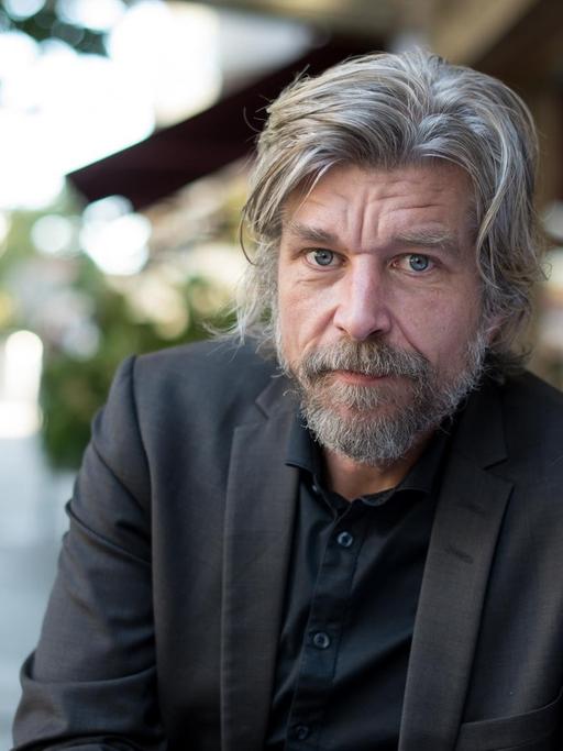 Der norwegische Schriftsteller Karl Ove Knausgård sitzt am 02.10.2015 vor einem Hotel in Berlin.