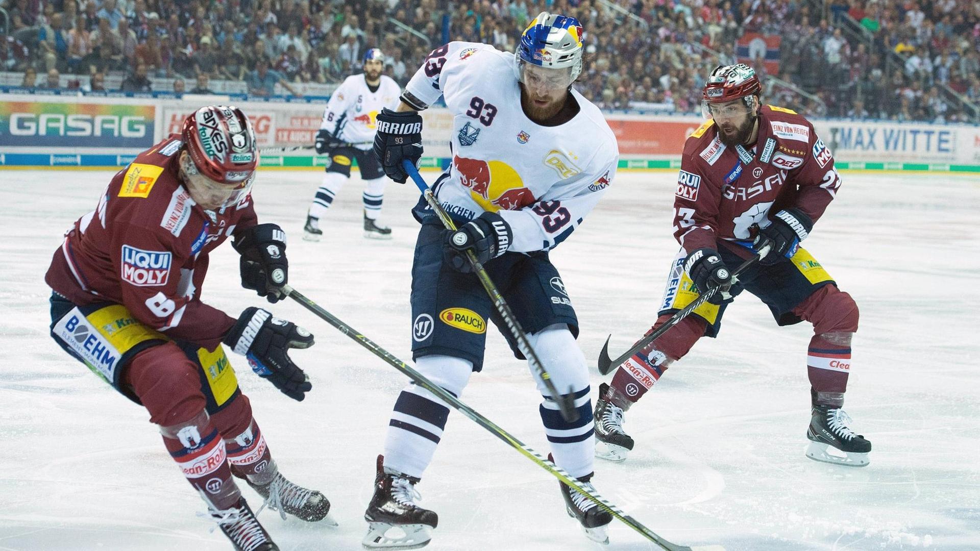 Die Eishockey-Spieler Kai Wissmann (Eisbären Berlin), Maximilian Kastner (EHC München), Thomas Oppenheimer (Eisbären Berlin) während eines Spiels auf der Eisfläche Die Eishockey-Spieler Kai Wissmann (Eisbären Berlin), Maximilian Kastner (EHC München), Thomas Oppenheimer (Eisbären Berlin) während eines Spiels auf der Eisfläche