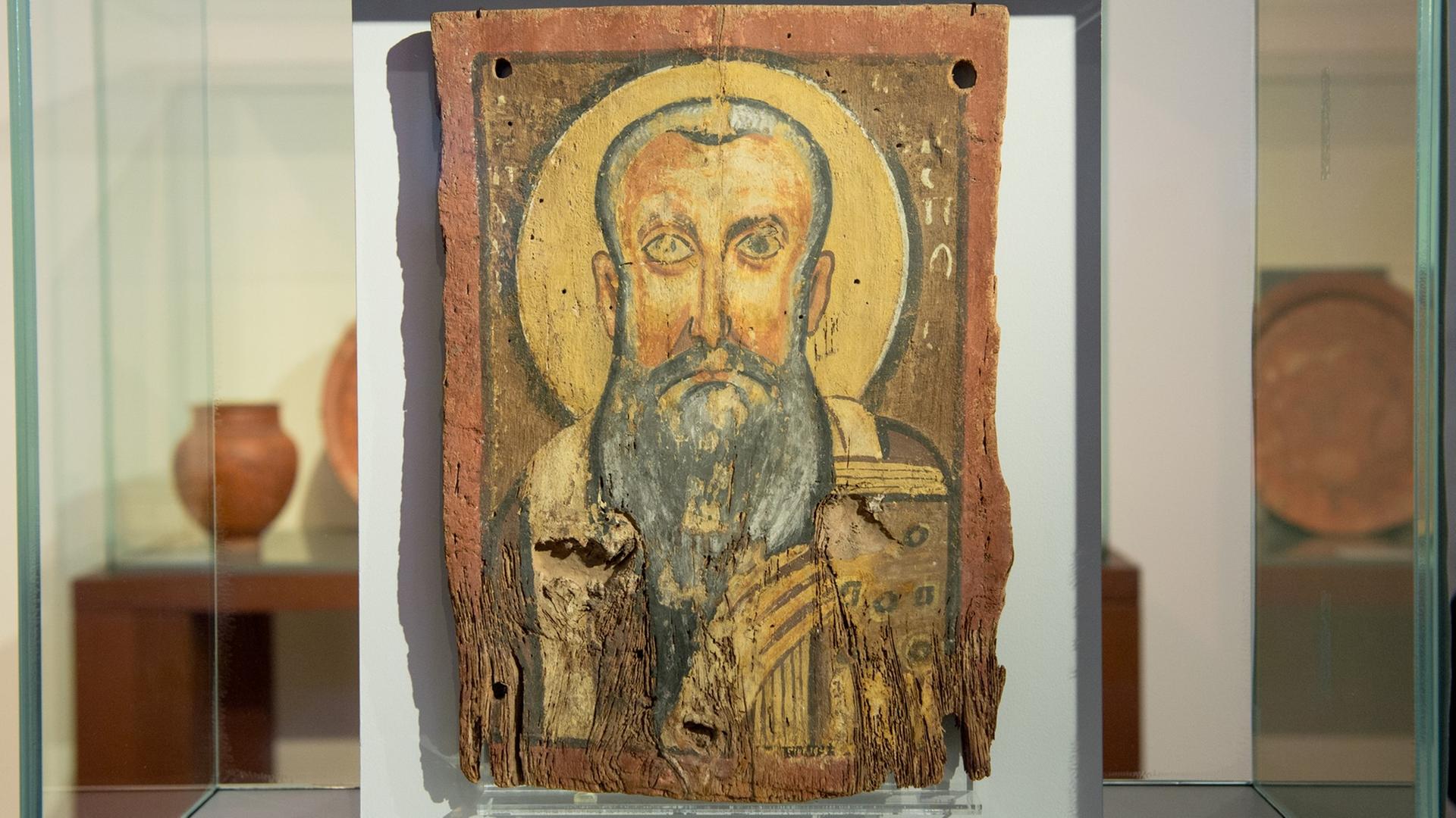 Die Ikone "Apa Abraham" in der Ausstellung "Ein Gott" im Berliner Bode-Museum. Ein gemaltes Bild eines Mannes mit grauem Bart auf rotem Stein, in einer Glasvitrine. Die Ikone "Apa Abraham" in der Ausstellung "Ein Gott" im Berliner Bode-Museum. Ein gemaltes Bild eines Mannes mit grauem Bart auf rotem Stein, in einer Glasvitrine.