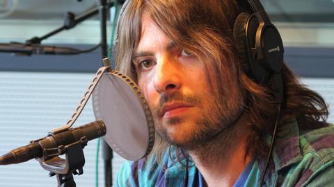 Der Sänger Robert Schwartzman sitzt im Studio von Deutschlandradio Kultur vor einem Mikrofon.