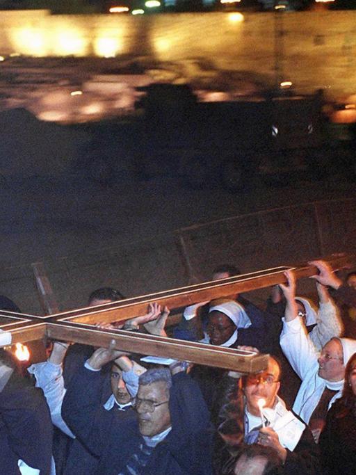 Christliche Pilger tragen zum Jahreswechsel '99/ 2000 in einer Lichterprozession ein riesiges Kreuz von der Gethsemane-Kirche zum Ölberg, der Leidensstätte Christi.