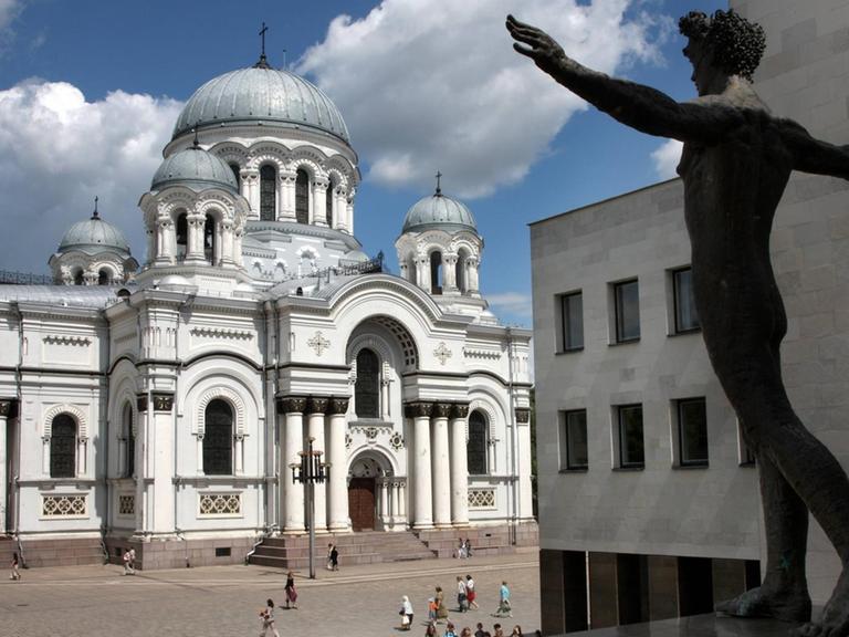 Skulptur eines Mannes mit ausgebreiteten Armen vor der Mykolas Zilinskas-Kunstgalerie und der Michaeliskirche im Zentrum von Kaunas in Litauen.