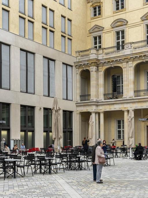 Blick in den Schlüterhof zwischen barocker und zeitgenössischer Fassade mit Besuchern vor einem Cafe.