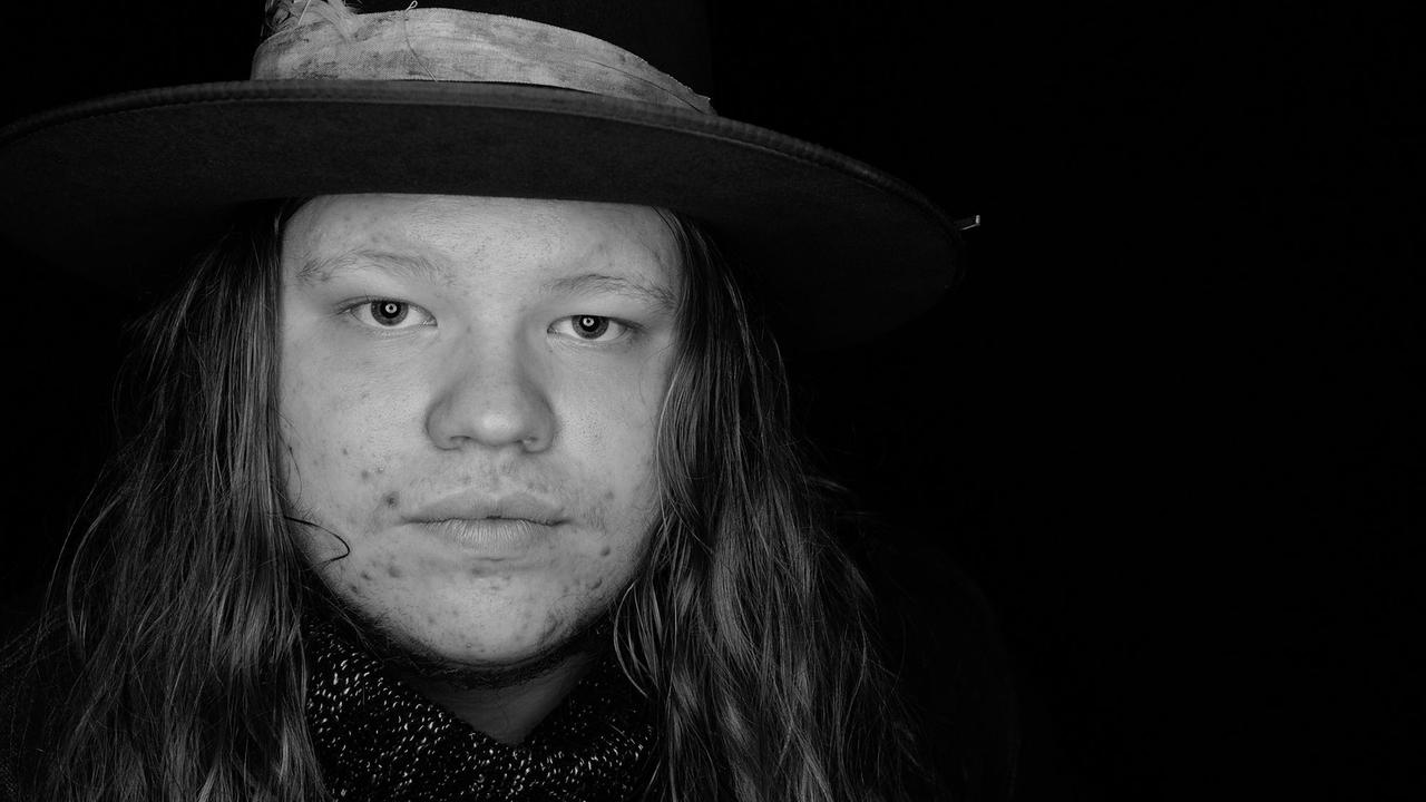 Schwarz-weiß-Porträt eines jungen Mannes mit blonden langen Haaren. Schwarz-weiß-Porträt eines jungen Mannes mit blonden langen Haaren.