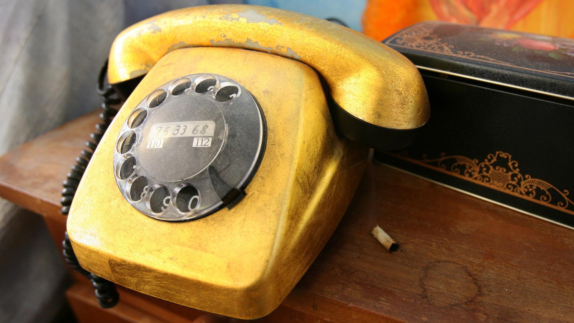 Ein goldfarben bemaltes Telefon.
