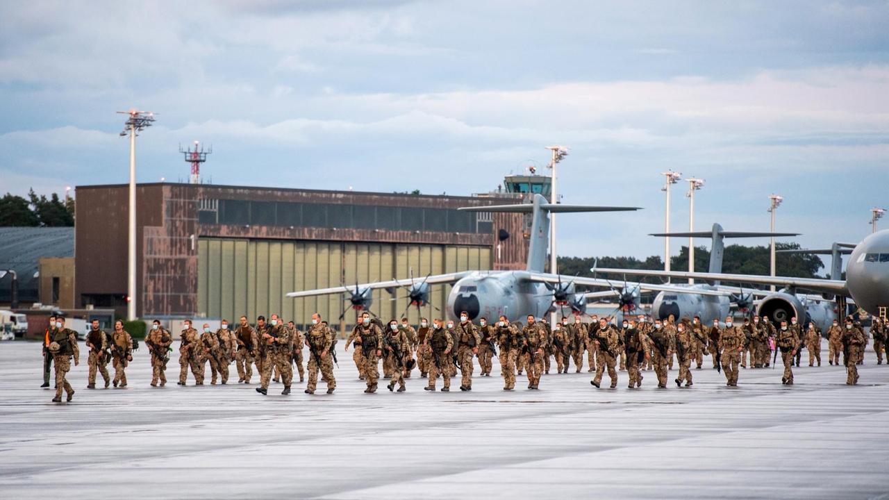 Soldaten steigen aus Transportflugzeugen der Bundeswehr aus und laufen über den Flugplatz