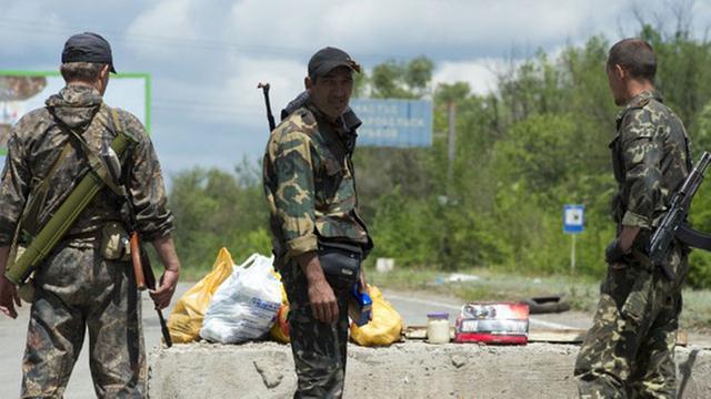 Bewaffnete pro-russische Separatisten bewachen am 28.06.2014 einen Checkpoint im Norden von Lugansk in der Ost-Ukraine.
