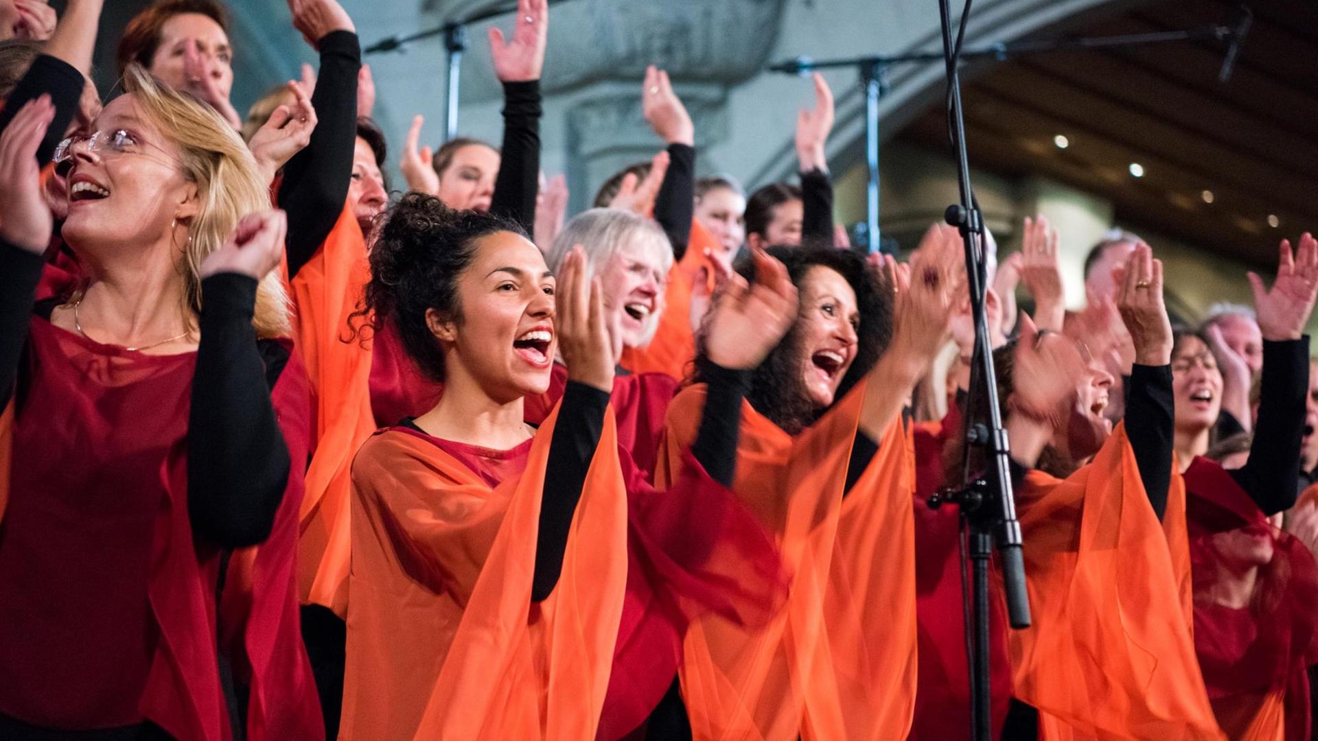 Sängerinnen des Chores bei einem Konzert. Sie singen, sie klatschen in die Hände und tanzen dazu. Sängerinnen des Chores bei einem Konzert. Sie singen, sie klatschen in die Hände und tanzen dazu.