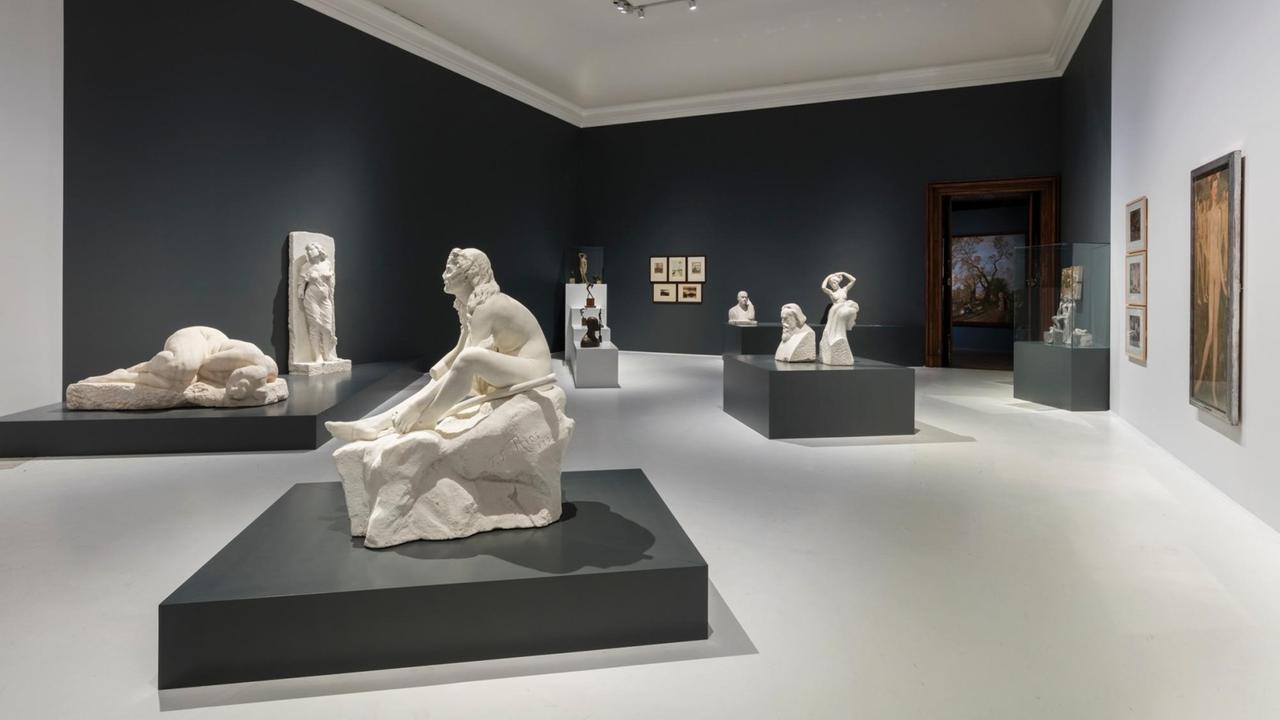 Blick in einen Ausstellungsraum der mit Skulpturen und Gemälden bestückt ist. Blick in einen Ausstellungsraum der mit Skulpturen und Gemälden bestückt ist.