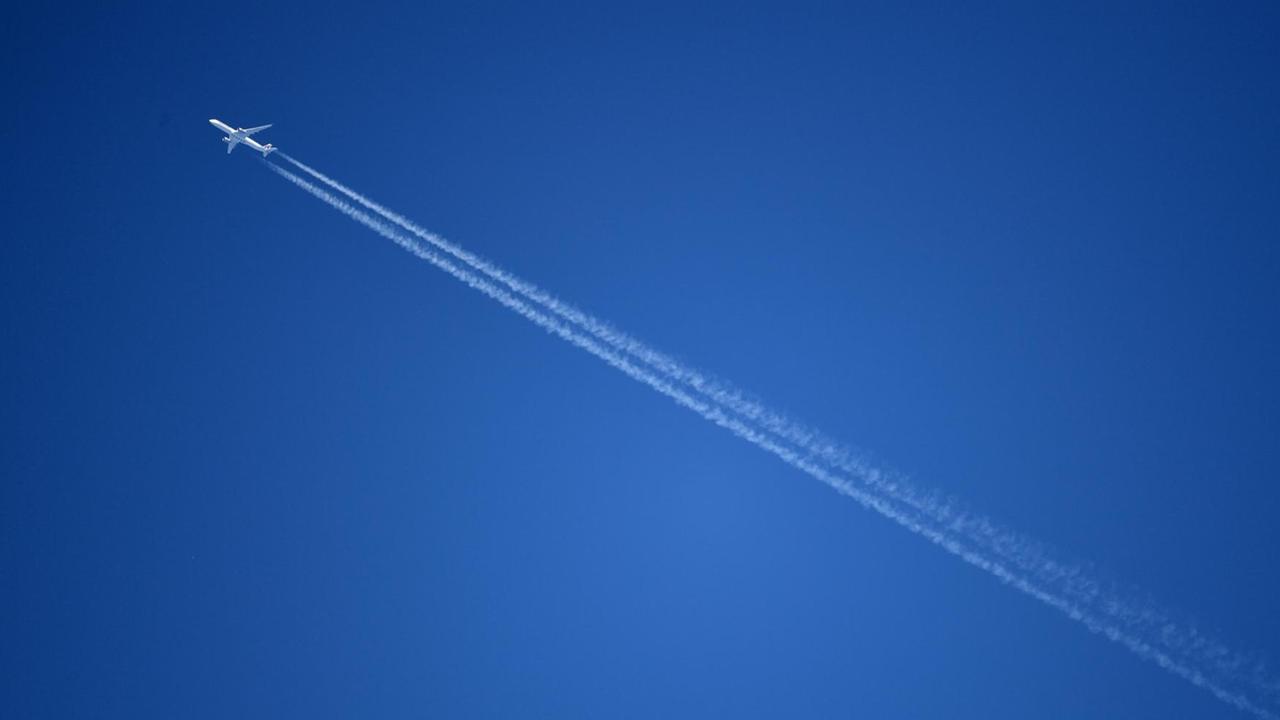 Ein Flugzeug fliegt durch den blauen Himmel. Ein Flugzeug fliegt durch den blauen Himmel.