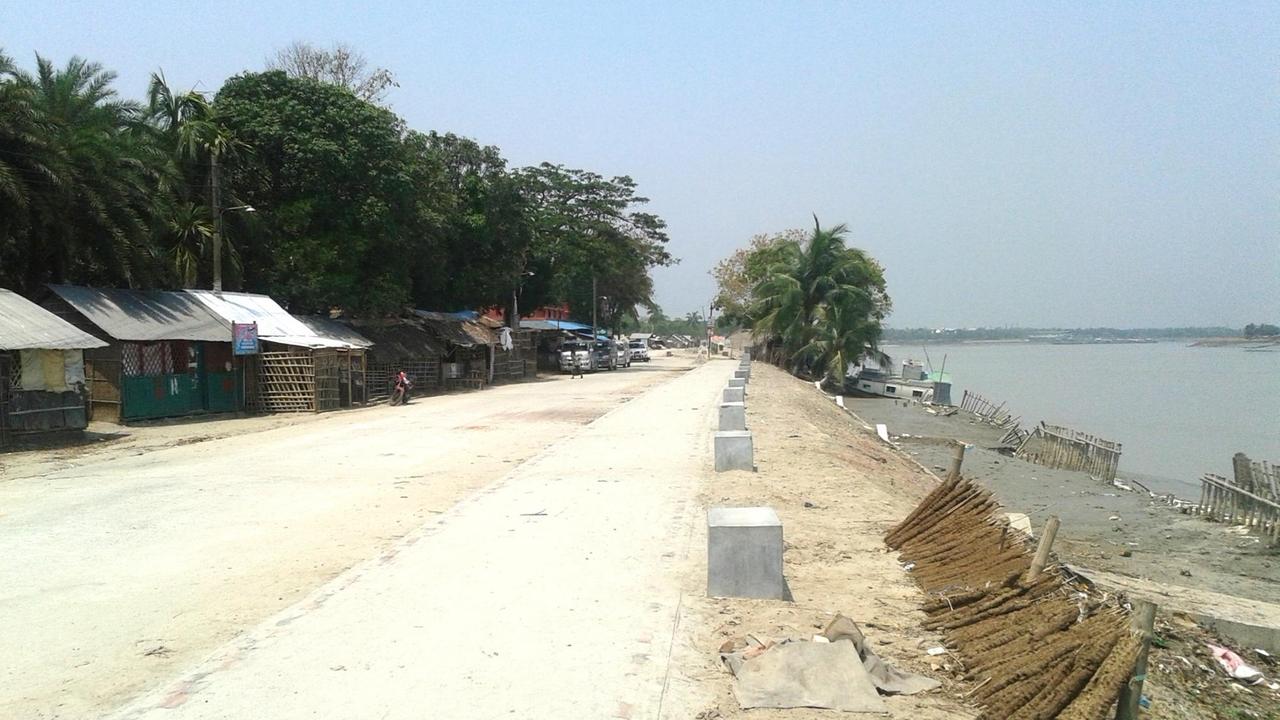 Der Poirob River mit einem neuen Staudamm und einer höheren Straße. Dahinter liegt die Armensiedlung von Khulna. Der Poirob River mit einem neuen Staudamm und einer höheren Straße. Dahinter liegt die Armensiedlung von Khulna.