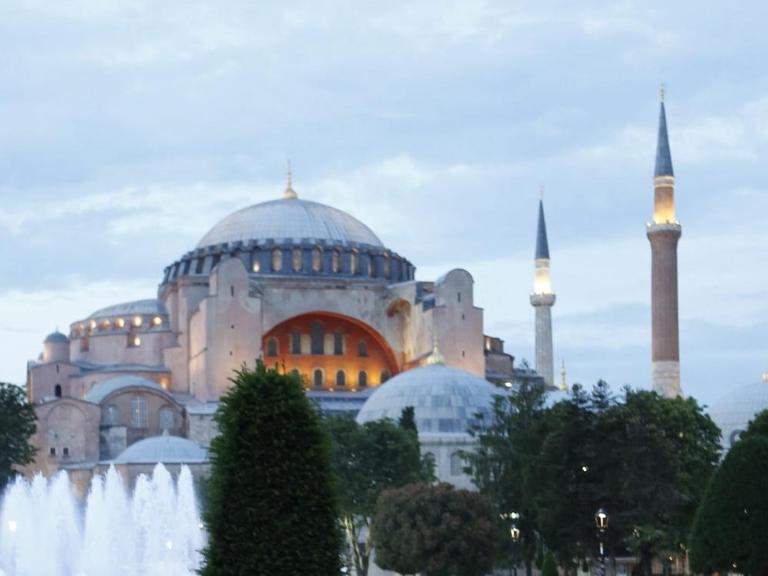 Muslime warten auf einer Grünfläche vor der Hagia Sophia in Istanbul darauf am ersten Tag des Fastenmonats Ramadan wieder etwas zu essen.