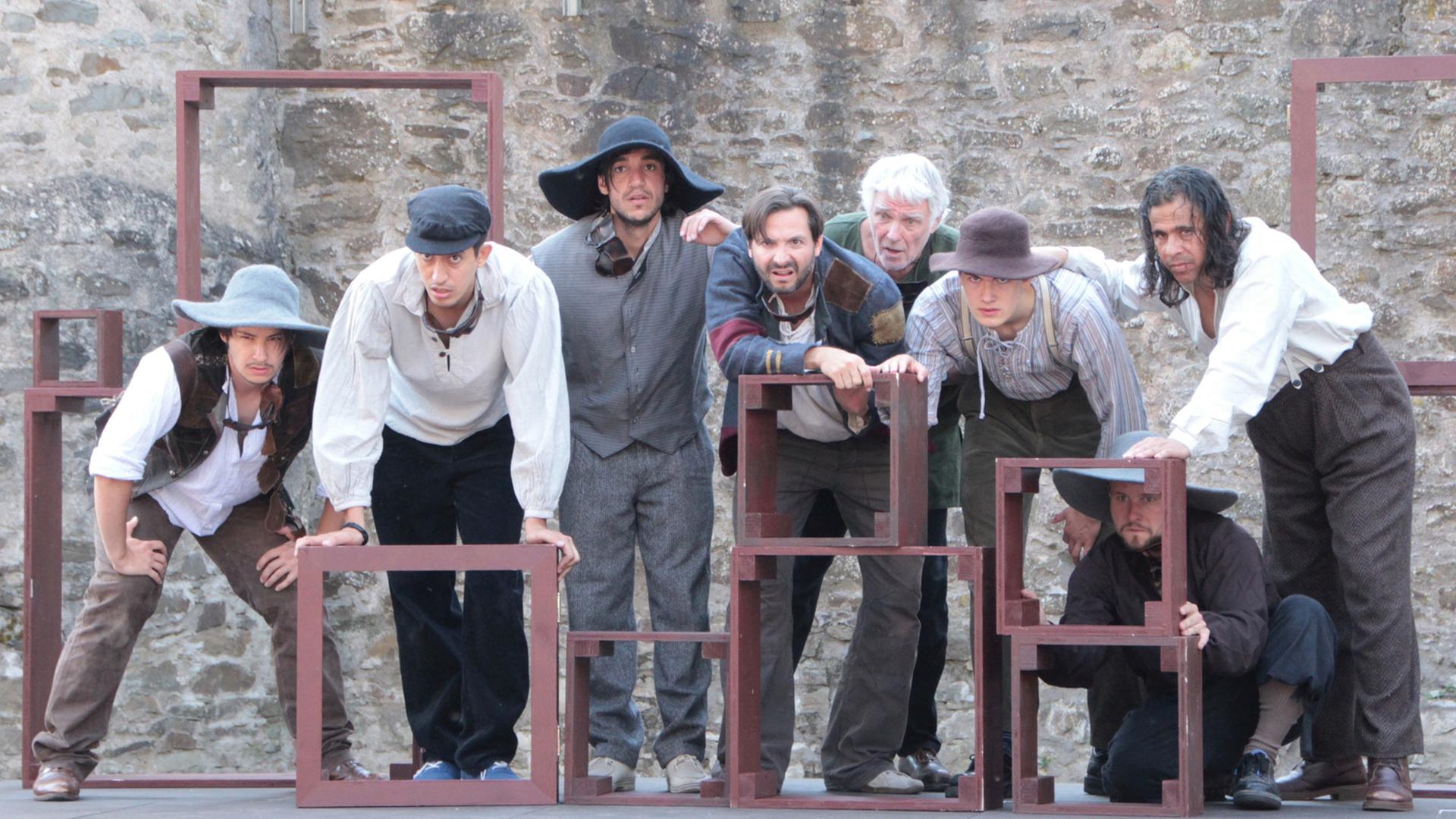 Zusammen mit syrischen Flüchtlingen (2./3.v.l. und ganz rechts) stehen am 08.08.2015 Schauspieler als "Räuber" in dem Stück "Der Postraub" bei den Schlossfestspielen im mittelhessischen Biedenkopf während einer Probe auf der Bühne. Zusammen mit syrischen Flüchtlingen (2./3.v.l. und ganz rechts) stehen am 08.08.2015 Schauspieler als "Räuber" in dem Stück "Der Postraub" bei den Schlossfestspielen im mittelhessischen Biedenkopf während einer Probe auf der Bühne.