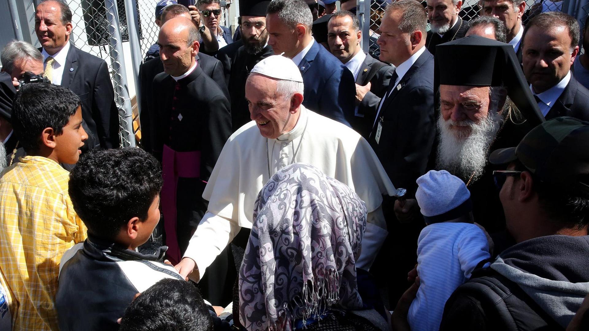 Papst Franziskus wird beim Besuch des Flüchtlingslagers Moria auf der griechischen Insel Lesbos von Flüchtlingskindern besucht. Er wird begleitert von Bartolomaios, dem orthodoxen Patriarchen von Konstantinopel. Papst Franziskus wird beim Besuch des Flüchtlingslagers Moria auf der griechischen Insel Lesbos von Flüchtlingskindern besucht. Er wird begleitert von Bartolomaios, dem orthodoxen Patriarchen von Konstantinopel.