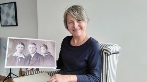 Friederike Fechner hält eine historische Fotografie von Carl Blach und seinen beiden Söhnen in ihren Händen.
