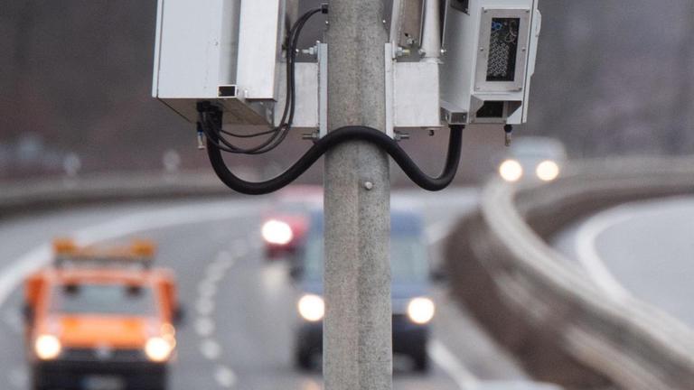 An der Auto-Bahn steht ein Mast mit Kameras. An der Auto-Bahn steht ein Mast mit Kameras.