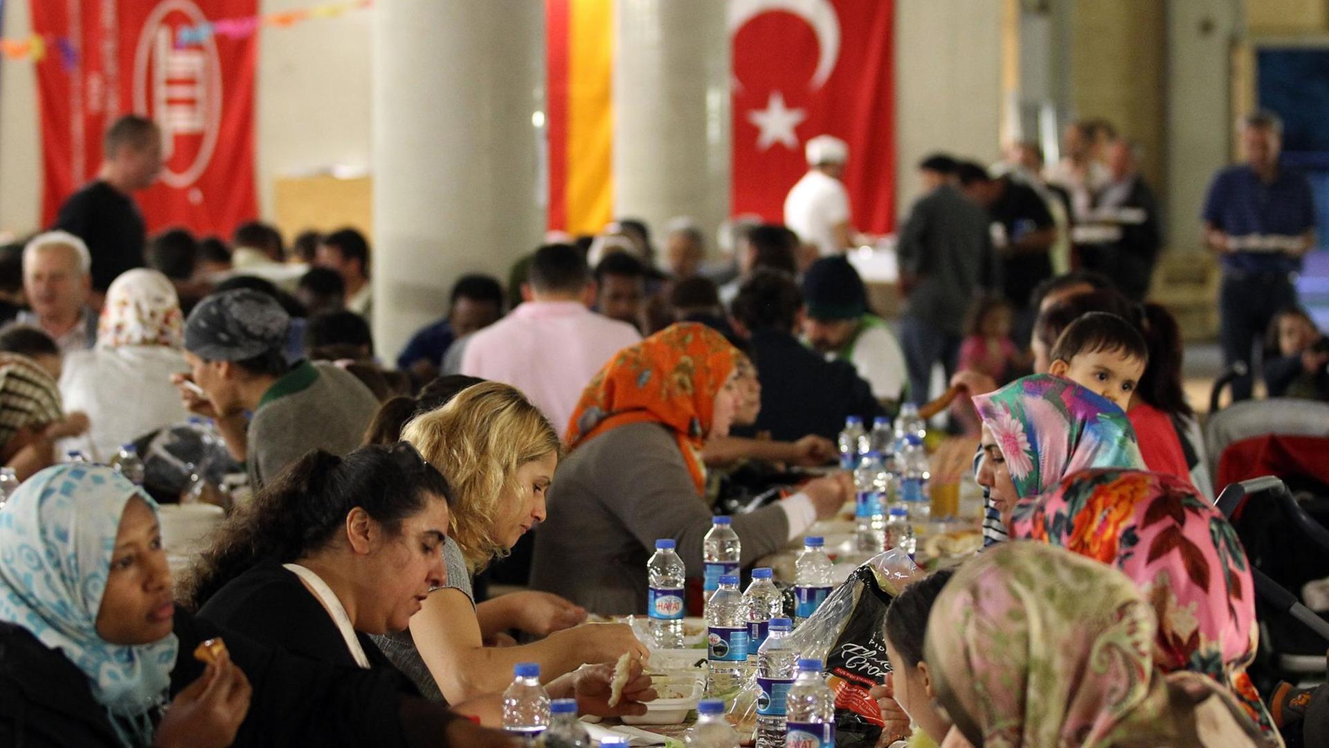 ARCHIV - Gläubige Muslime essen am 09.08.2012 in Köln in der Moschee beim gemeinsamen Fastenbrechen (Iftar). Von Samstag an verzichten gläubige Muslime tagsüber auf Essen und Trinken - bis zum 27. Juli dauert der Fastenmonat Ramadan.