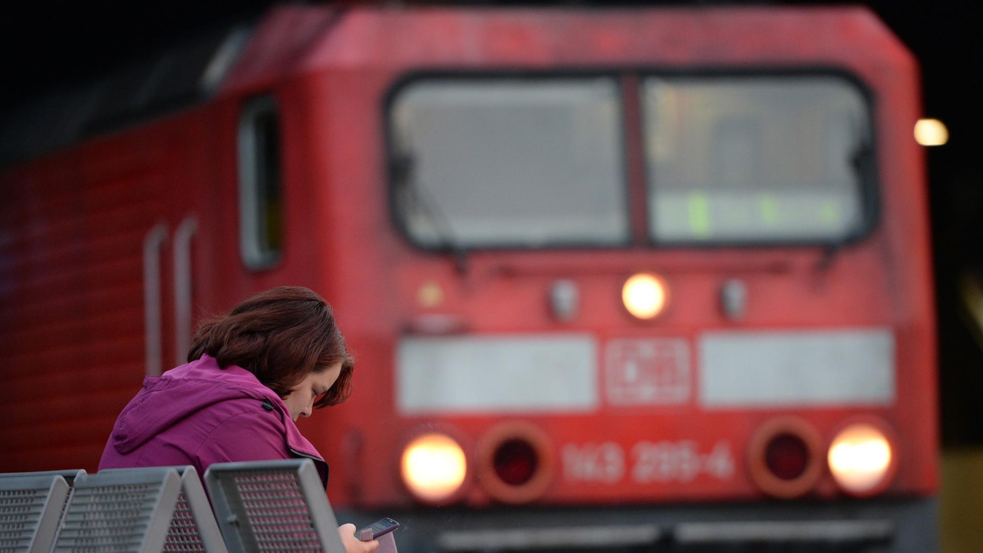 Eine Frau sitzt am 06.09.2014 im Hauptbahnhof in Hamburg vor einem Triebwagen der Bahn. Eine Frau sitzt am 06.09.2014 im Hauptbahnhof in Hamburg vor einem Triebwagen der Bahn.