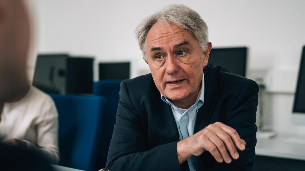 Der Journalist und Journalistikprofessor Volker Lilienthal sitzt an einem Tisch und blickt sein Gegenüber an, das im Bild nicht erkenntlich ist. Der Journalist und Journalistikprofessor Volker Lilienthal sitzt an einem Tisch und blickt sein Gegenüber an, das im Bild nicht erkenntlich ist.