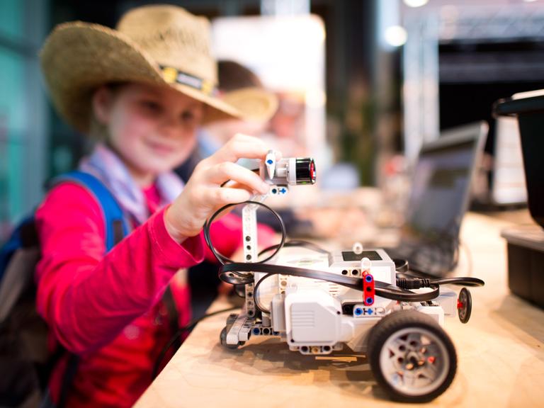 Die sechsjährige Jette bastelt am 7.4.2014 bei der Hannover Messe an einem kleinen Roboter.