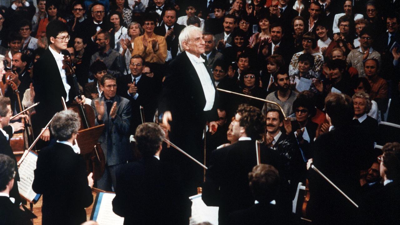 Leonard Bernstein dirigiert am 25. Dezember 1989 das mit einem internationalen Ensemble besetzte Ost-West-Konzert in Berlin. Leonard Bernstein dirigiert am 25. Dezember 1989 das mit einem internationalen Ensemble besetzte Ost-West-Konzert in Berlin.