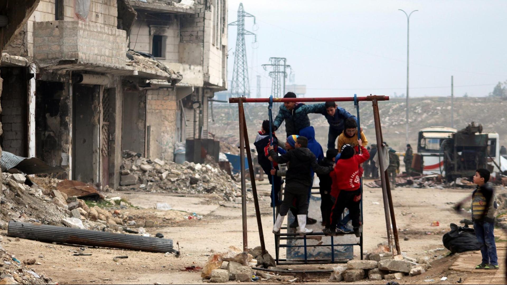 Kinder spielen in Aleppo vor zerstörten Gebäuden Kinder spielen in Aleppo vor zerstörten Gebäuden