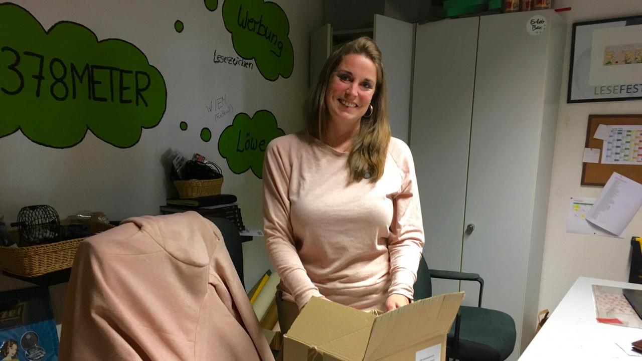 Eine Frau in ihrem Büro vor einem Karton Eine Frau in ihrem Büro vor einem Karton