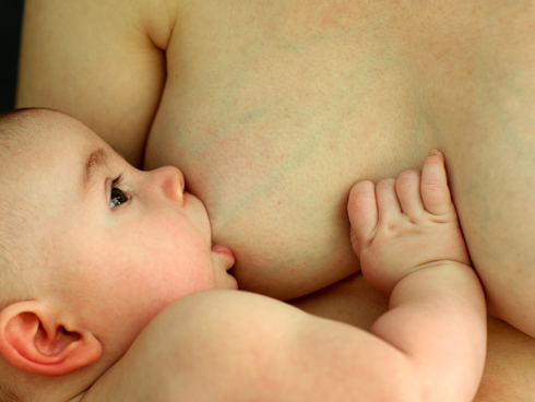 Eine Mutter stillt ihr drei Monate altes Baby