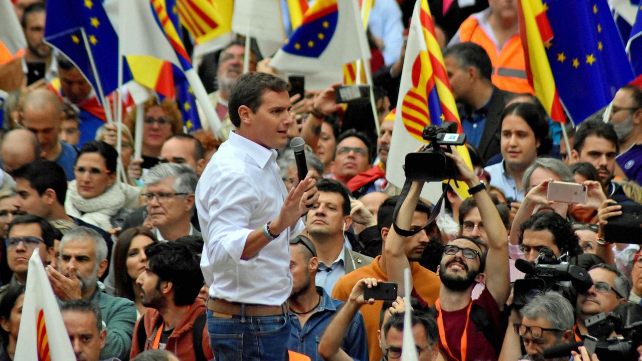 Albert Rivera, Vorsitzender der Partei Ciudadanos, redet auf der Plaça Sant Jaume in Barcelona im Oktober 2018 während einer Demonstration pro spanischer Verfassung – im Hintergrund sind Protestierende mit spanischen und europäischen Fahnen zu sehen. Albert Rivera, Vorsitzender der Partei Ciudadanos, redet auf der Plaça Sant Jaume in Barcelona im Oktober 2018 während einer Demonstration pro spanischer Verfassung – im Hintergrund sind Protestierende mit spanischen und europäischen Fahnen zu sehen.
