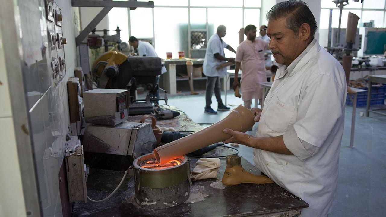 Ein Mitarbeiter verwandelt bei Jaipur Foot ein Wasserrohr zu einer Prothese Ein Mitarbeiter verwandelt bei Jaipur Foot ein Wasserrohr zu einer Prothese
