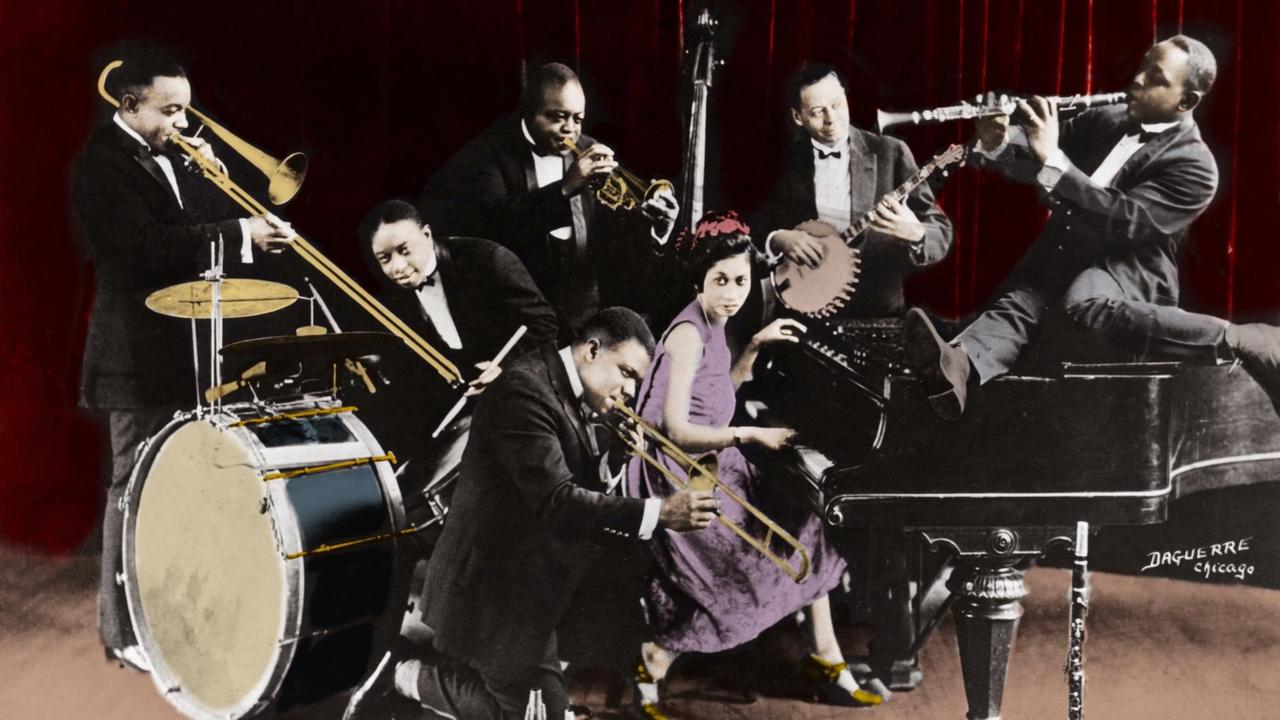 Eine nachkolorierte historische Aufnahme zeigt Louis Armstrong mit der King Oliver's Creole Jazz Band in Chicago 1923 mit Baby Dodds , Honore Dutry, King Oliver , Bill Johnson, Johny Dodds (Klarinette) und Lilian Hardin Armstrong (Ehefrau von Louis Armstrong).