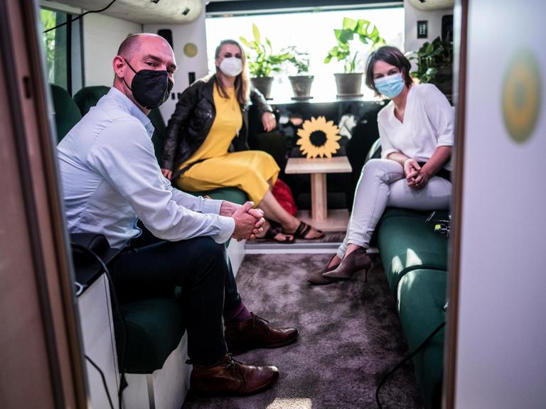 Annalena Baerbock, Jagoda Marinić und Korbinian Frenzel sitzen im Bus der Grünen.