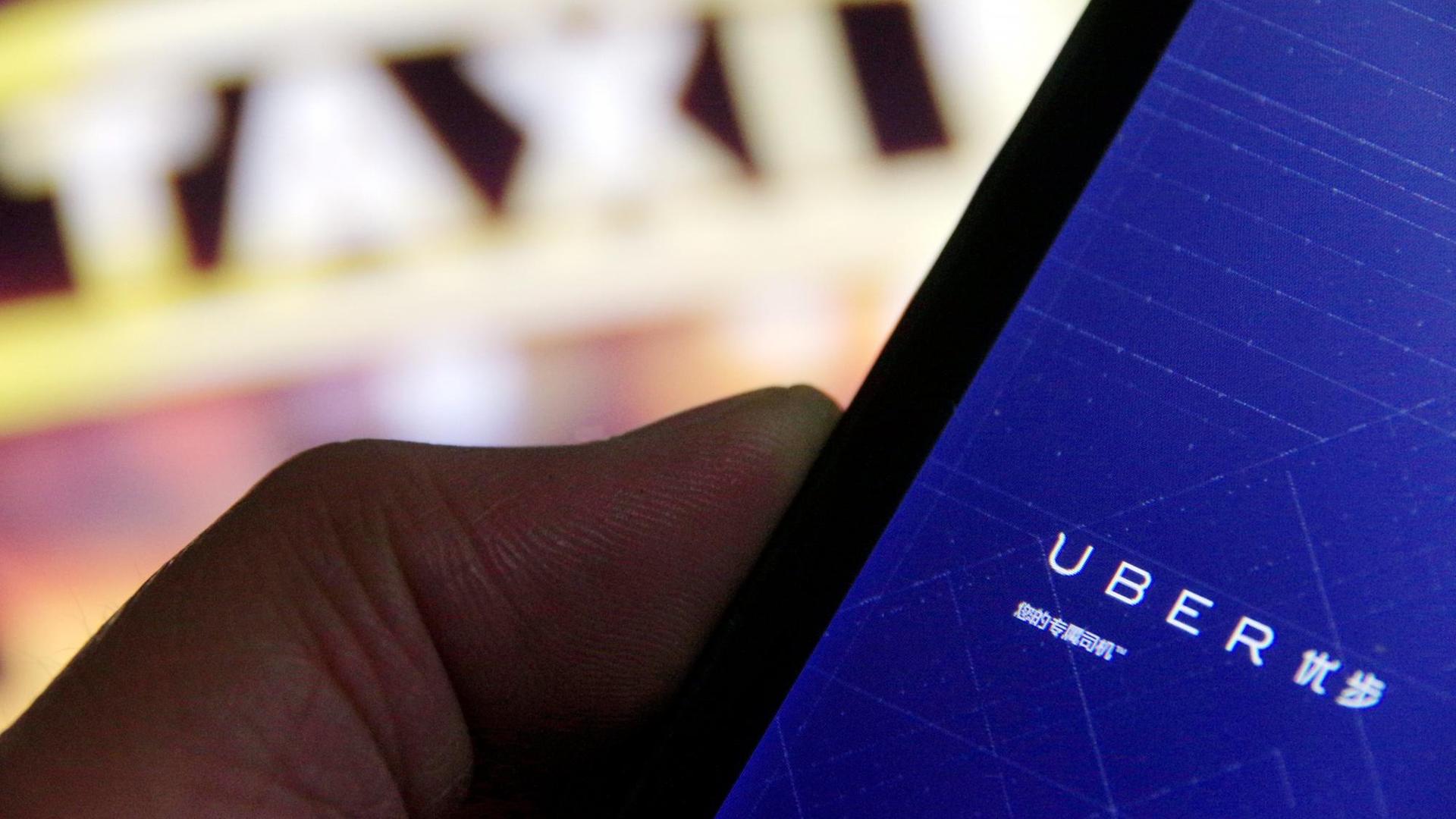 Ein Mann benutzt auf seinem Smartphone Uber, die Taxi-App. Ein Mann benutzt auf seinem Smartphone Uber, die Taxi-App.