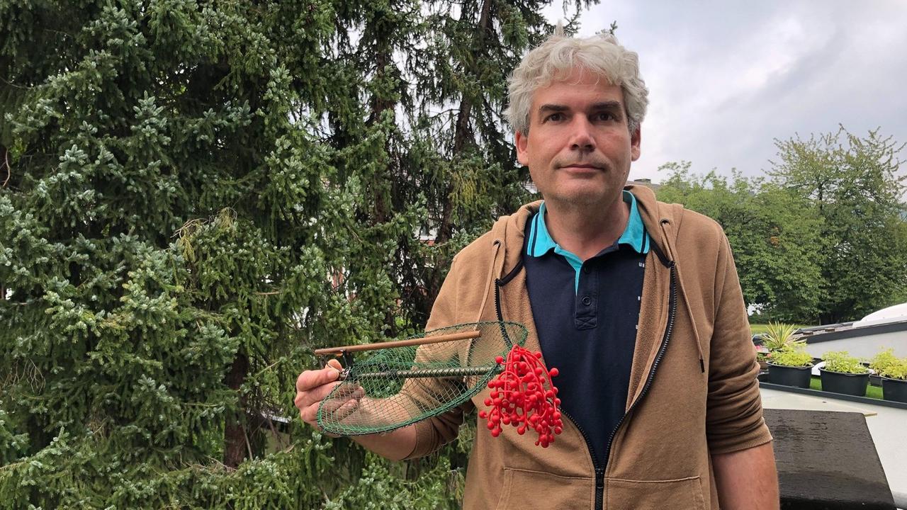 Axel Hirschfeld vom Komitee gegen den Vogelmord (Bonn) hält eine "Schmetterlingsfalle" zum Vogelfang in der Hand