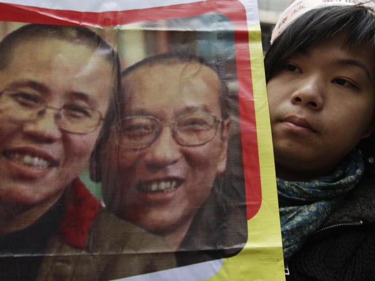 Eine Demonstrantin in China hält ein Bild von Friedensnobelpreisträger Liu Xiaobo und seiner Frau Lia Xia hoch (Archivbild aus dem Jahr 2010).