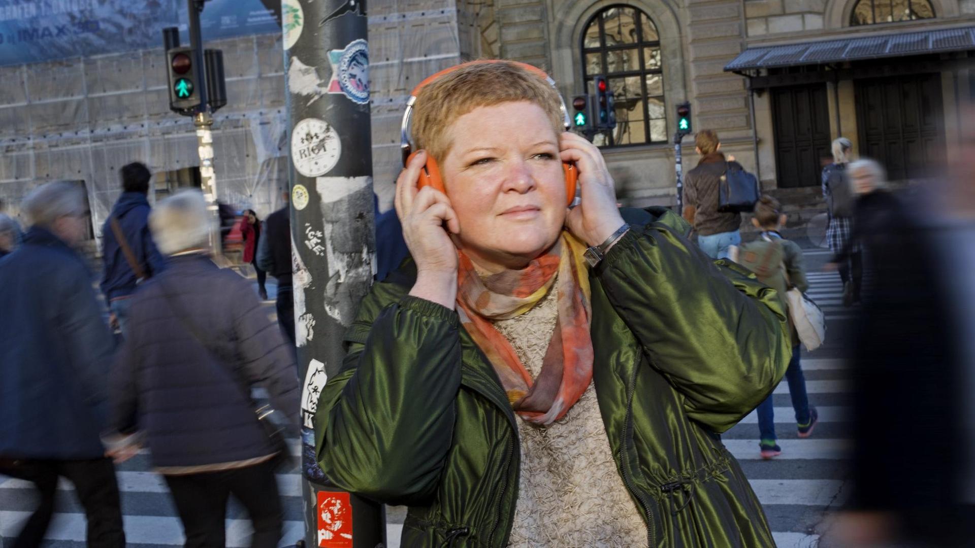 Auf dem Bild ist die Radiomacherin Susanna Sommer zu sehen. Sie drückt sich einen Kopfhörer an die Ohren und lächelt. Auf dem Bild ist die Radiomacherin Susanna Sommer zu sehen. Sie drückt sich einen Kopfhörer an die Ohren und lächelt.