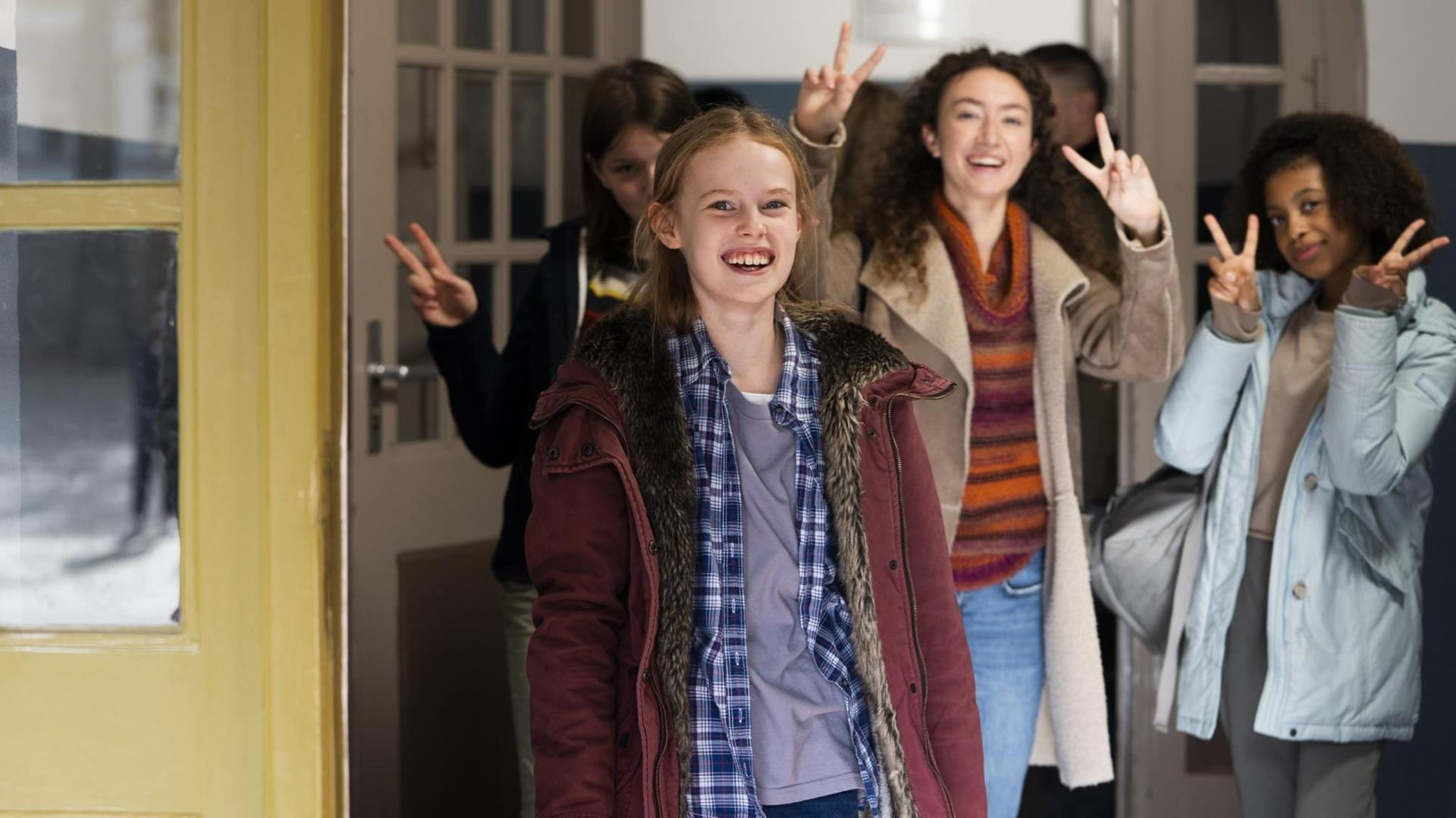 Mirella Schulze im Vordergrund, hinter her Klassenkameradinnen, die das Peace-Zeichen machen. Mirella Schulze im Vordergrund, hinter her Klassenkameradinnen, die das Peace-Zeichen machen.