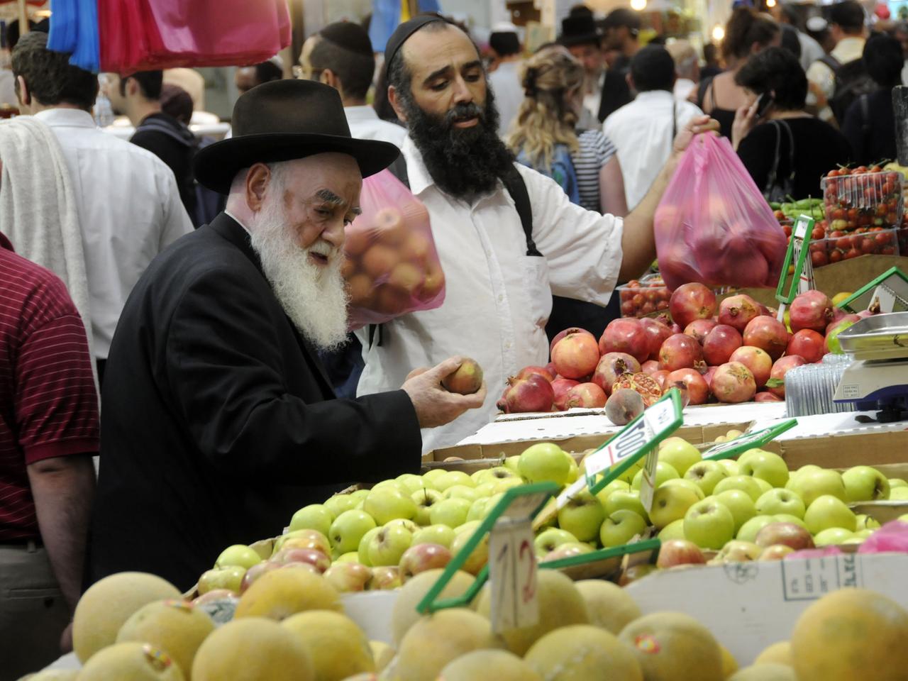 Israelis kaufen Obst auf einem Markt.