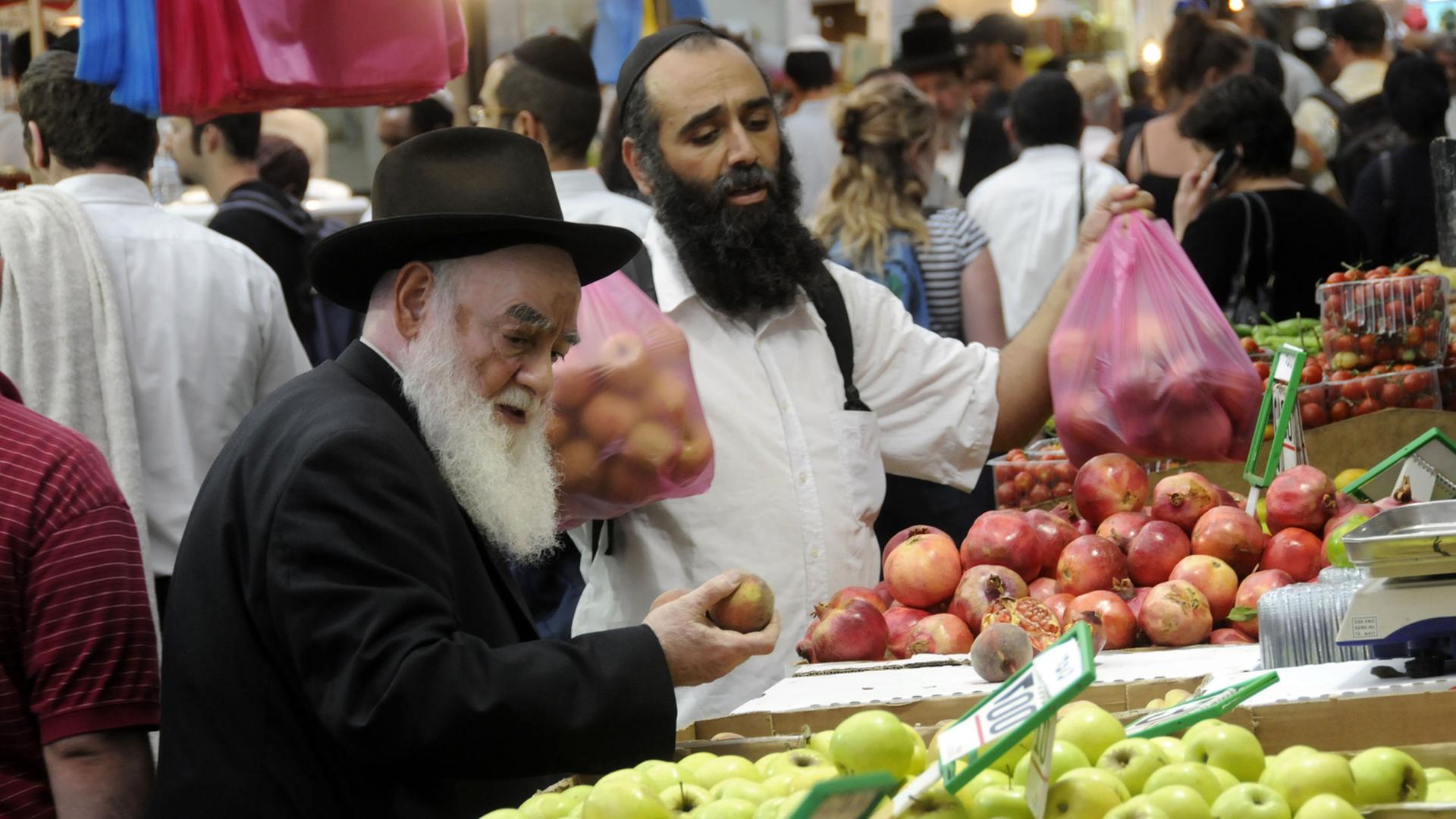 Israelis kaufen Obst auf einem Markt.