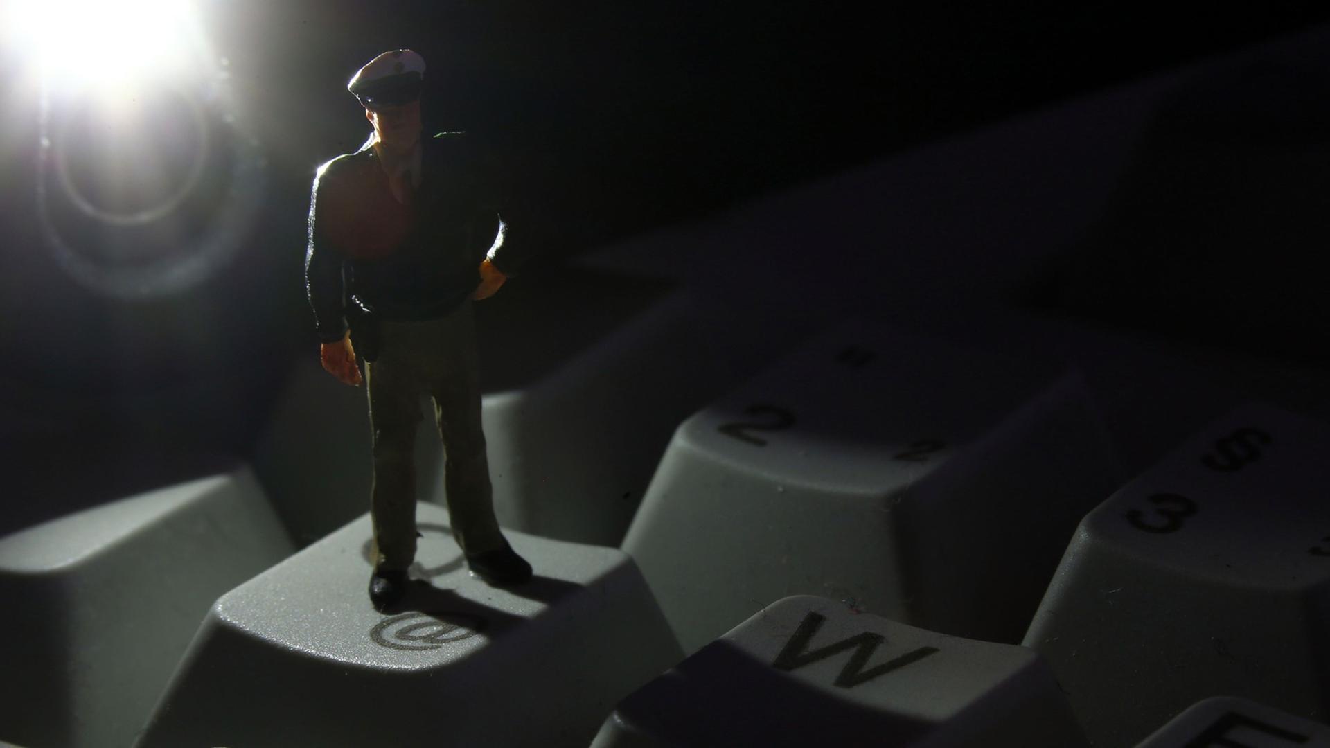 Eine Minifigur eines Polizisten auf der Tastatur eines Rechners Eine Minifigur eines Polizisten auf der Tastatur eines Rechners